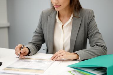 Aoife Brennan checking payroll compliance documents at a tidy desk in Dublin